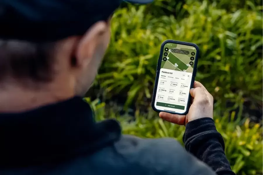 693759106134f1ff8dd5508b farmer holding phone viewing paddock ui 2x